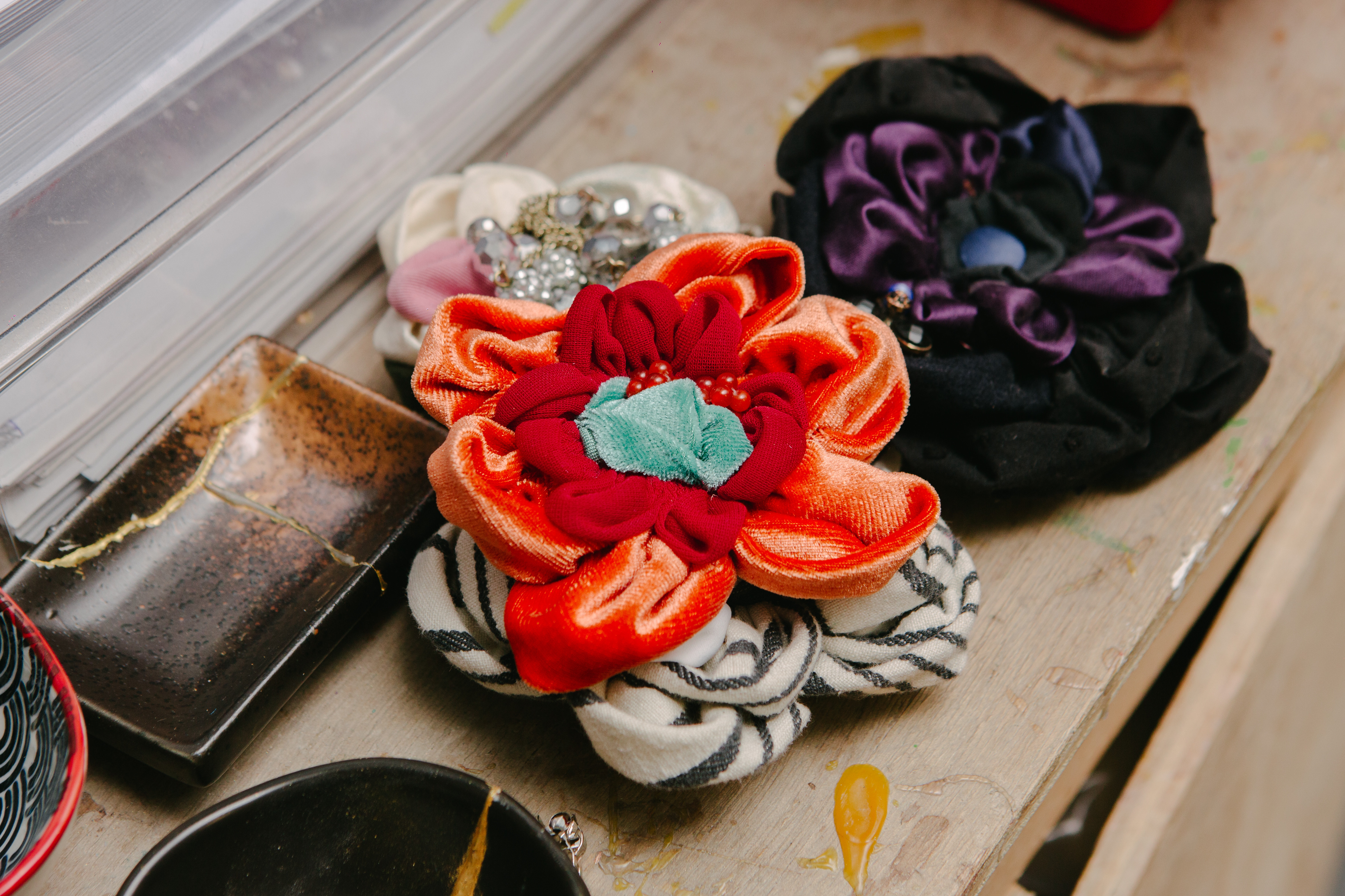 A close up of some handmade fabric flowers in various colours and patterns
